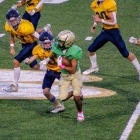 Silas Knuckles works on avoiding Marist defenders. Photo by Alicia Payne